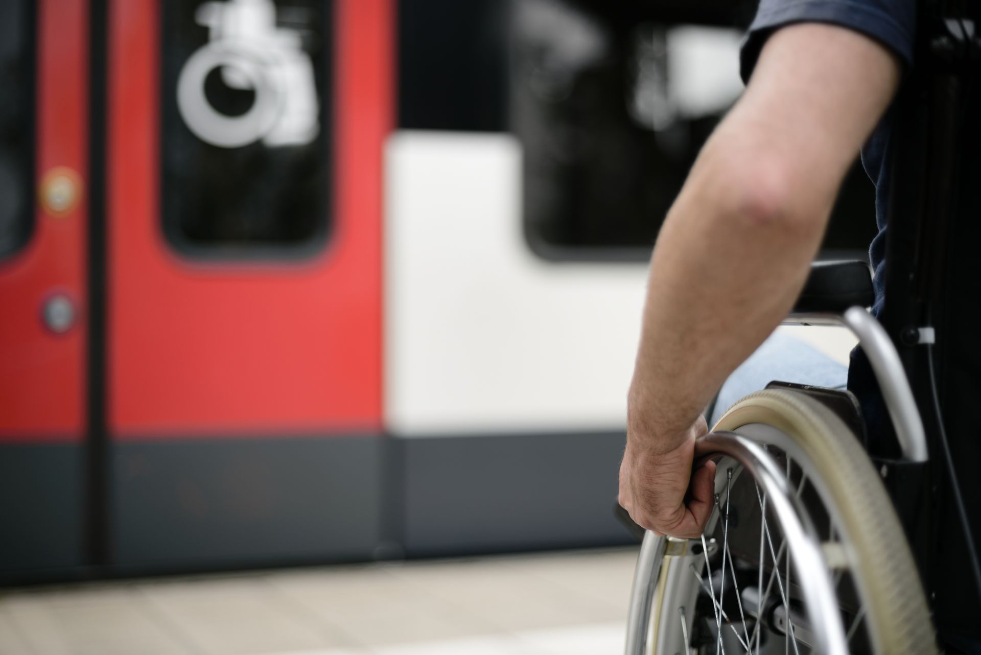 Foto von einem Rollstuhlfahrenden, der auf das Rollstuhlabteil eines Zuges zusteuert.